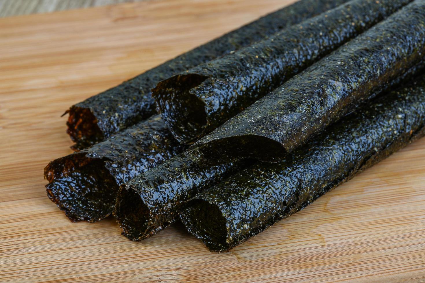 Seaweed rolls on wooden board and wooden background photo