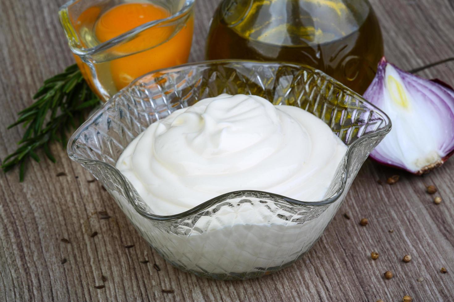 Mayonnaise sauce in a bowl on wooden background photo