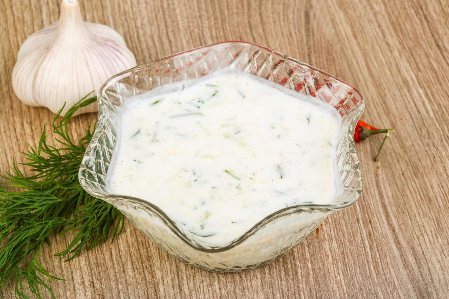 Tzatziki in a bowl on wooden background photo