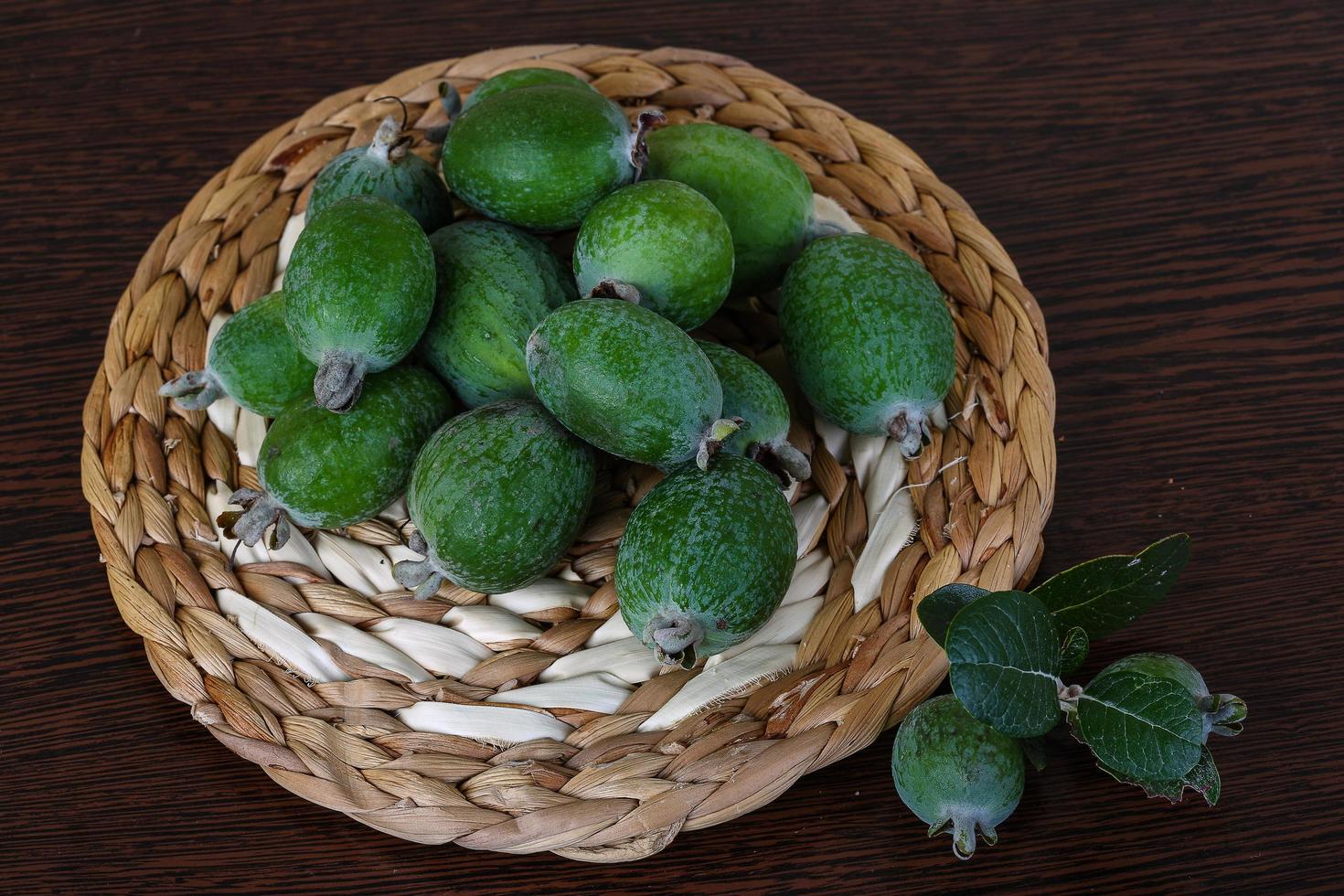 fruta feijoa sobre tablero de madera y fondo de madera foto