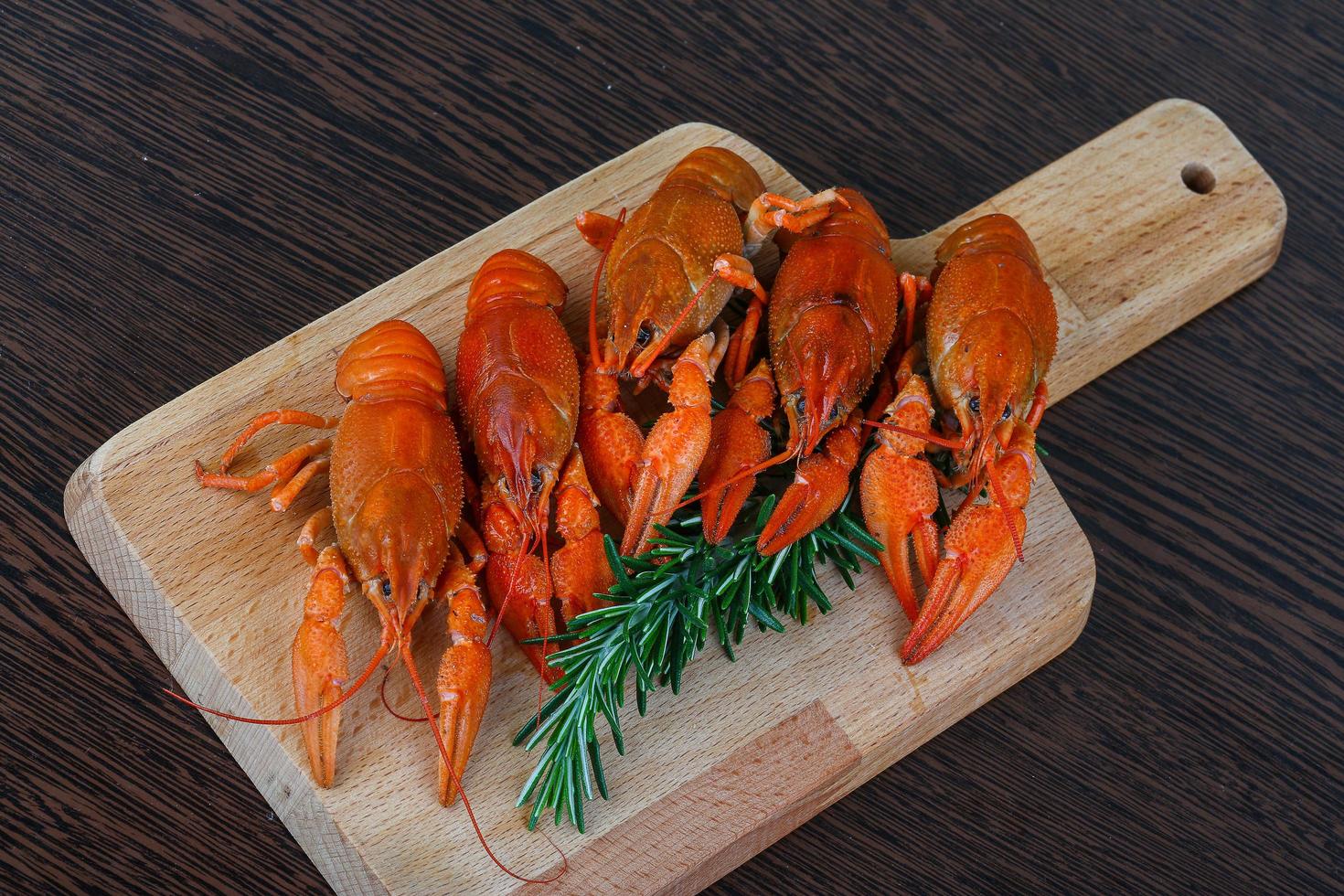 Crayfish on wooden board and wooden background photo