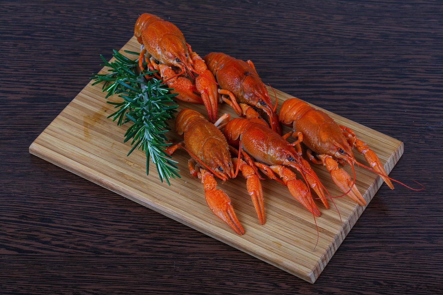 Crayfish on wooden board and wooden background photo