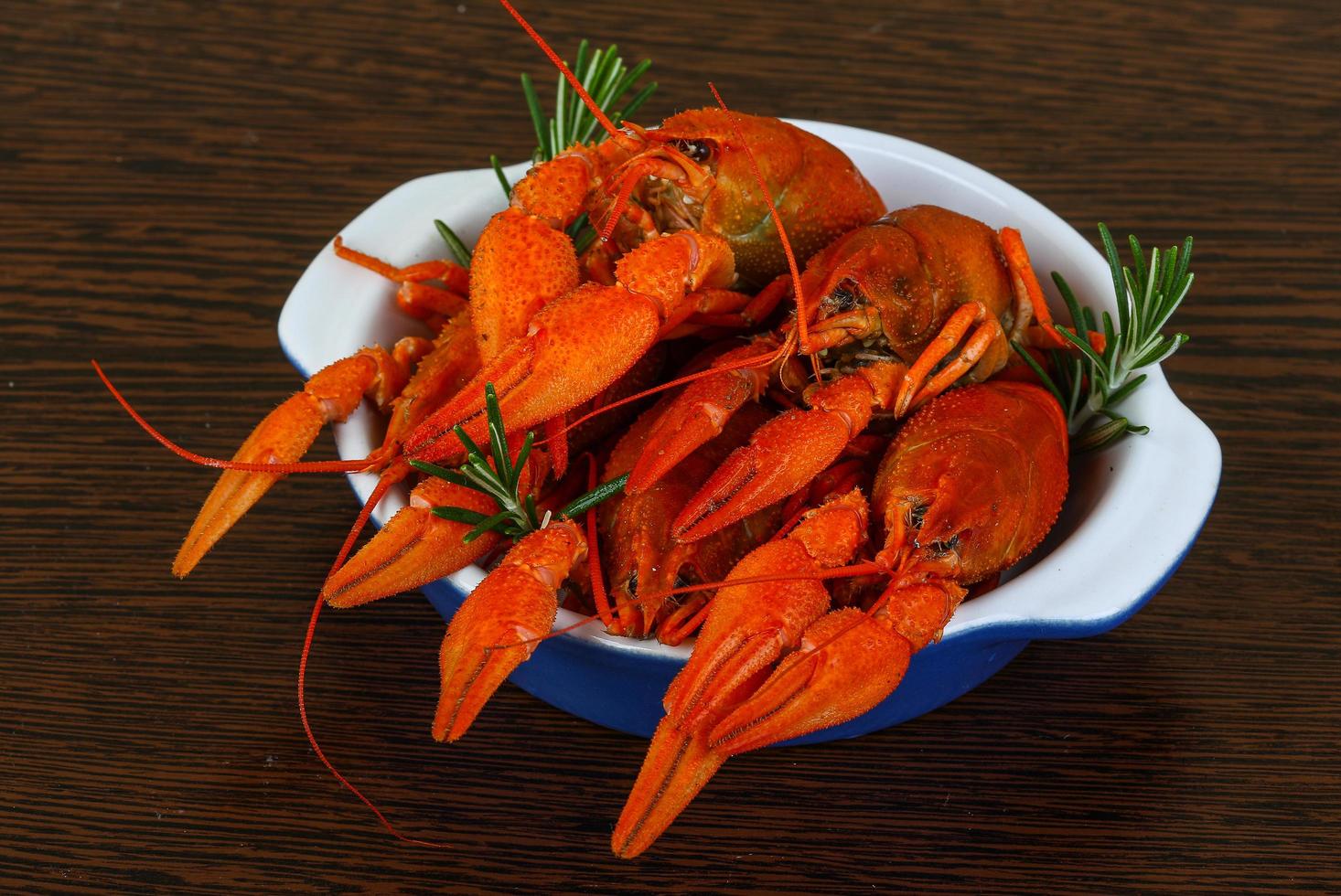 Crayfish in a bowl on wooden background photo