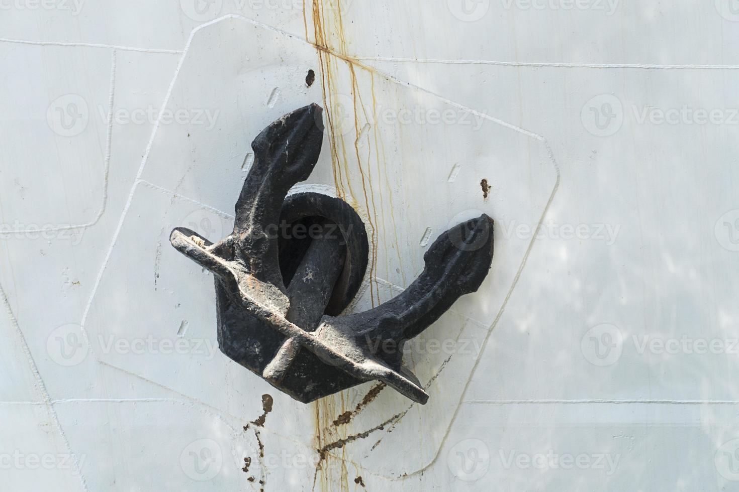 black ship anchor on white board photo