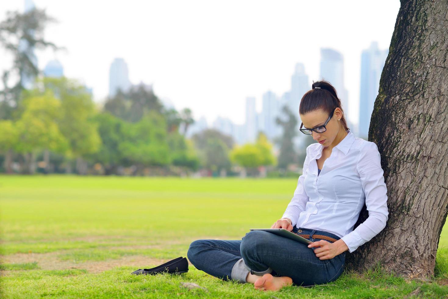 Beautiful young woman with  tablet in park photo