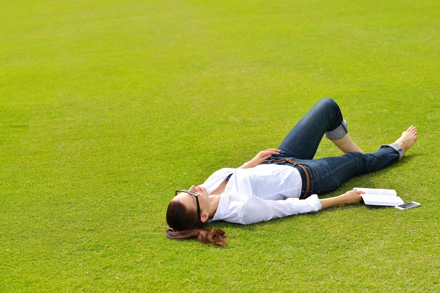 Young woman reading a book in the park photo