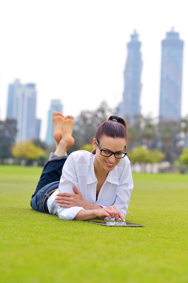 Beautiful young woman with  tablet in park photo