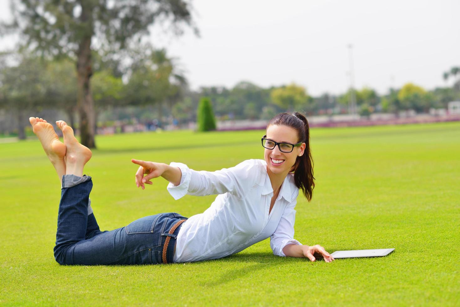 Beautiful young woman with  tablet in park photo