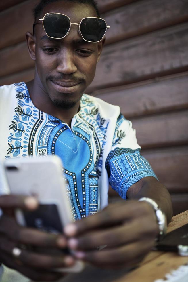 hombre negro africano nativo usando un teléfono inteligente foto