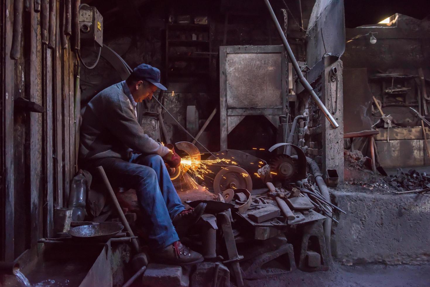 the blacksmith polishing metal products photo