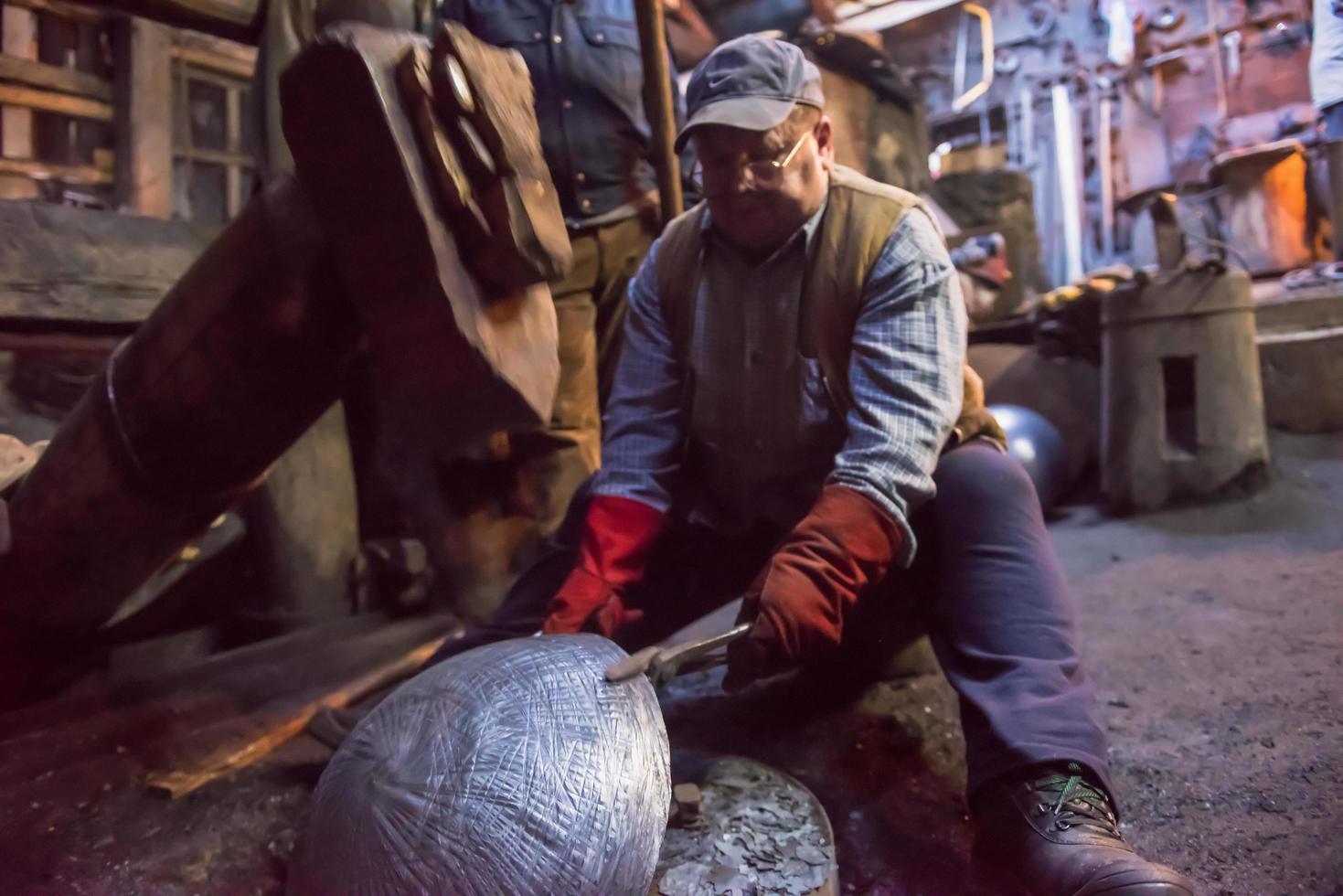 blacksmith workers using mechanical hammer at workshop photo