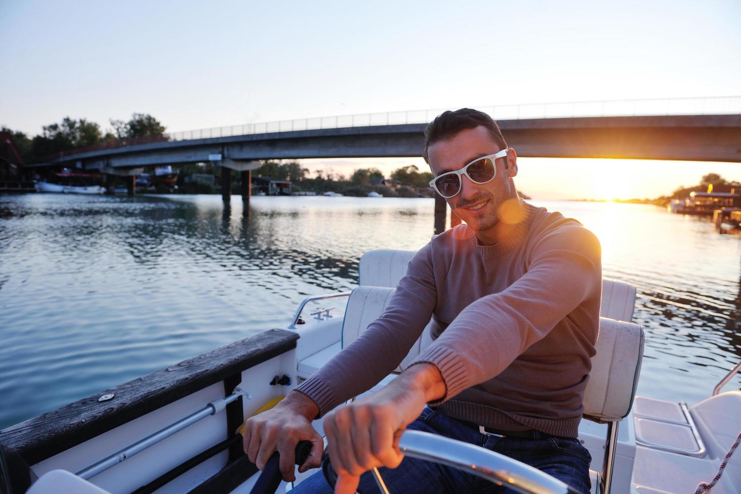 portrait of happy young man on boat photo