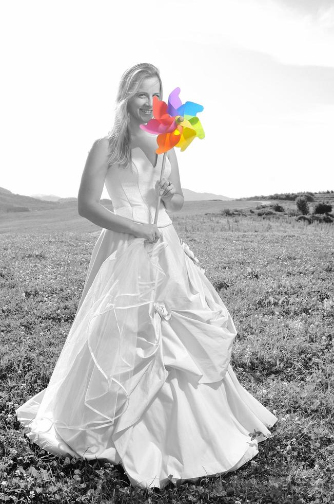 hermosa novia al aire libre con un colorido juguete de molino de viento foto