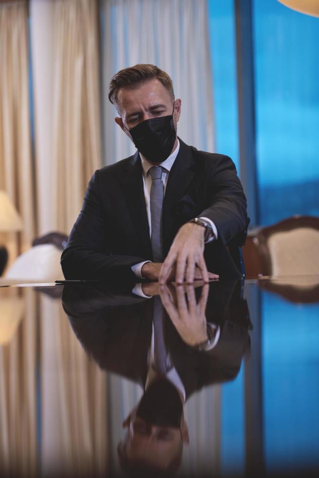 business man wearing protective face mask at luxury office photo