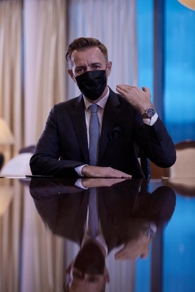 business man wearing protective face mask at luxury office photo