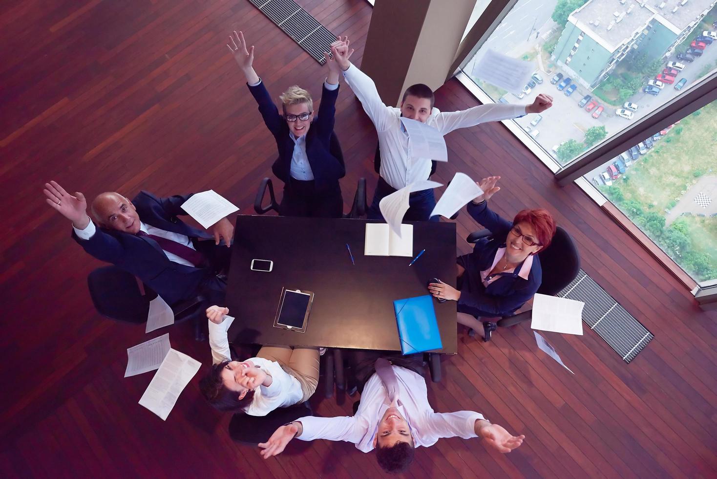 top view of business people group throwing dociments in air photo