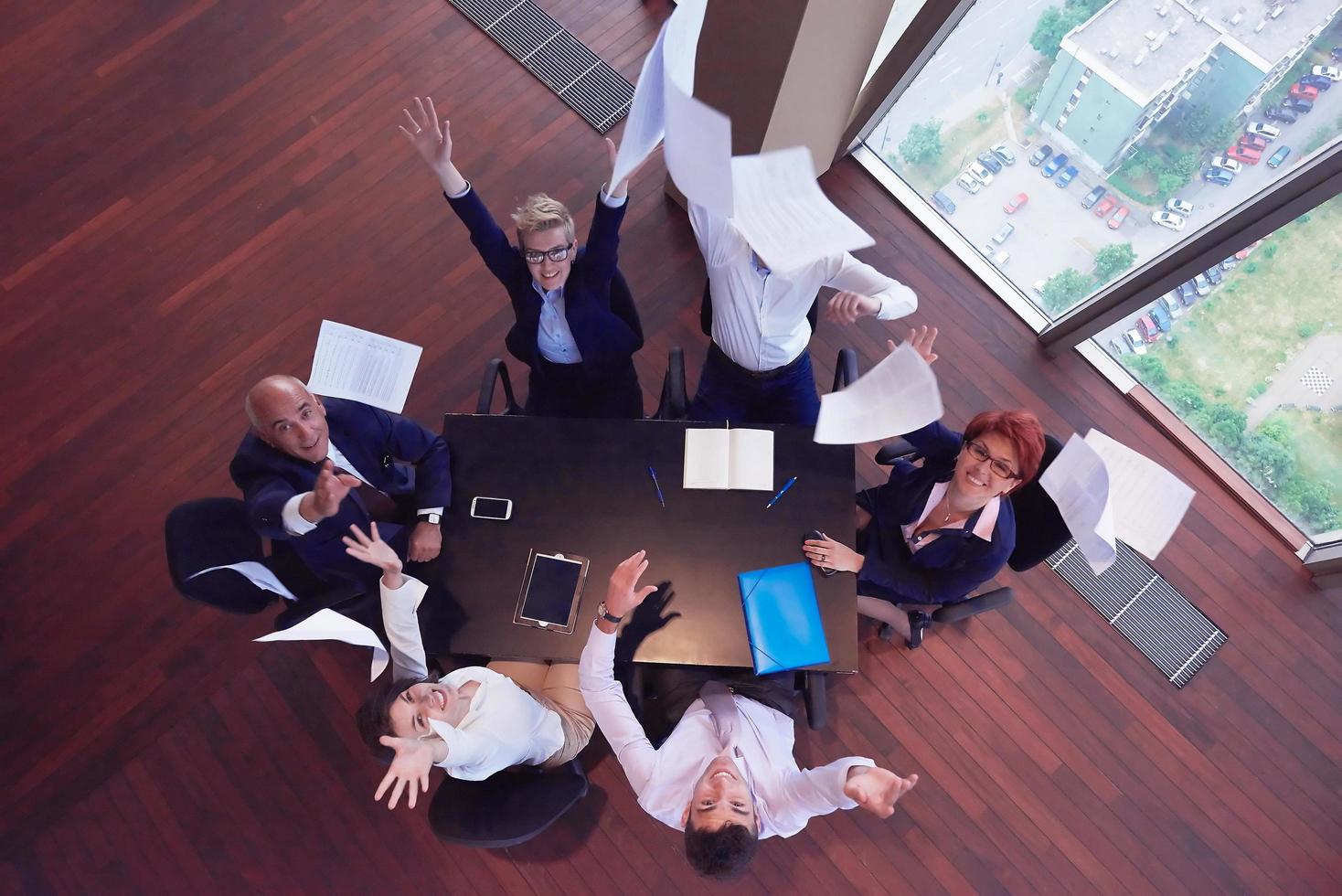 top view of business people group throwing dociments in air photo