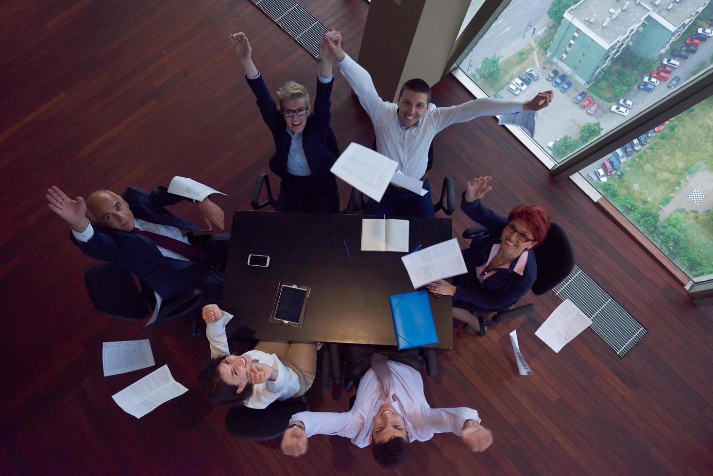 top view of business people group throwing dociments in air photo