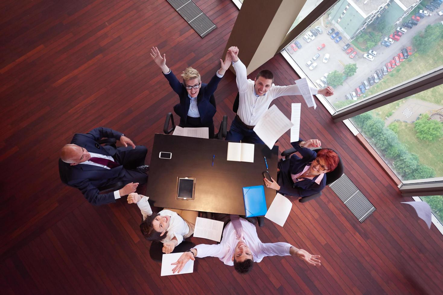 top view of business people group throwing dociments in air photo