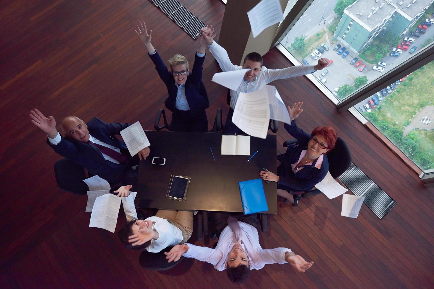 top view of business people group throwing dociments in air photo