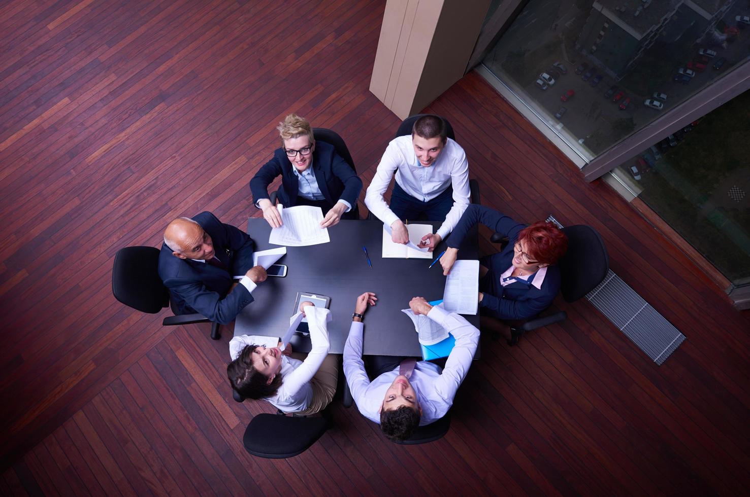 top view of business people group throwing dociments in air photo