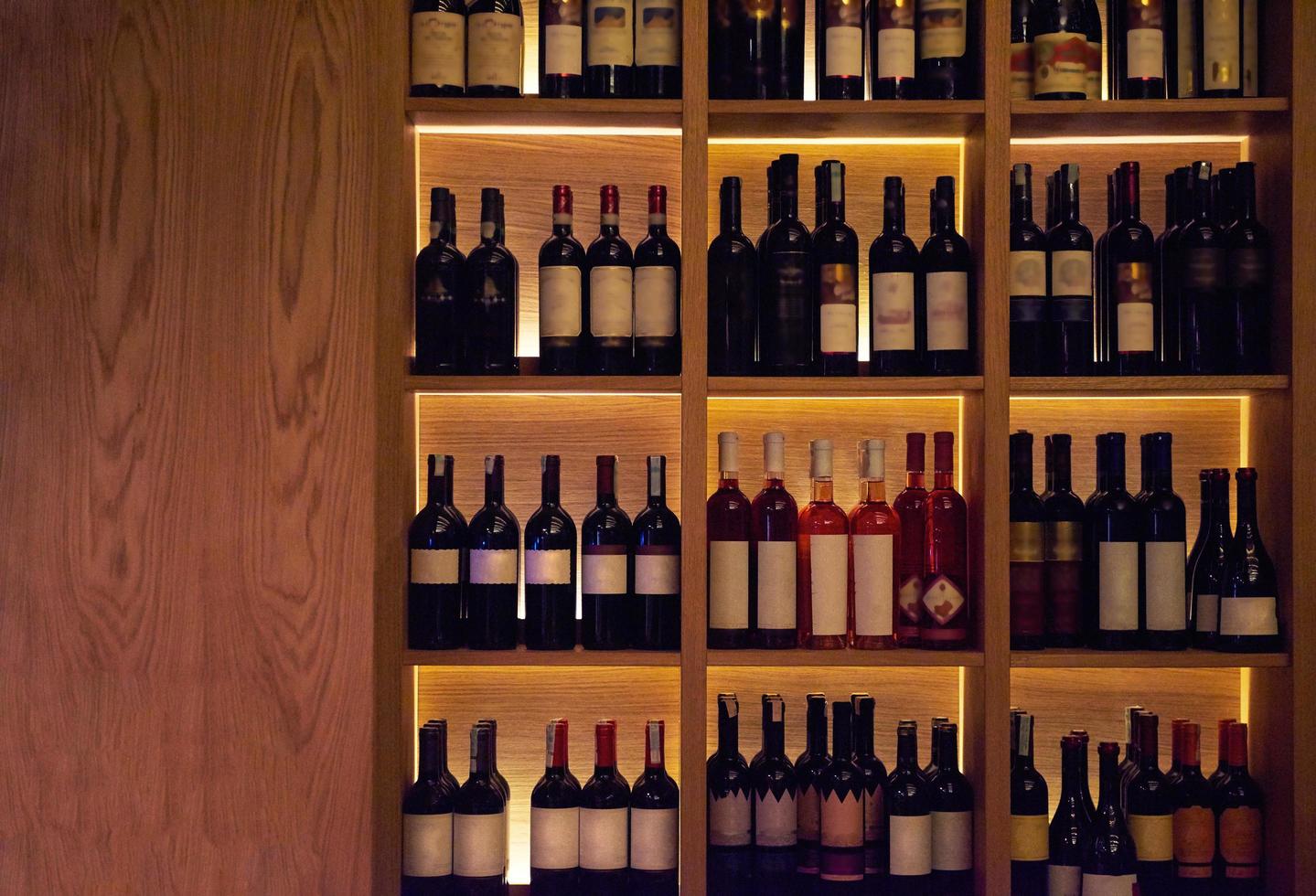 Wine bottles on a wooden shelf. photo