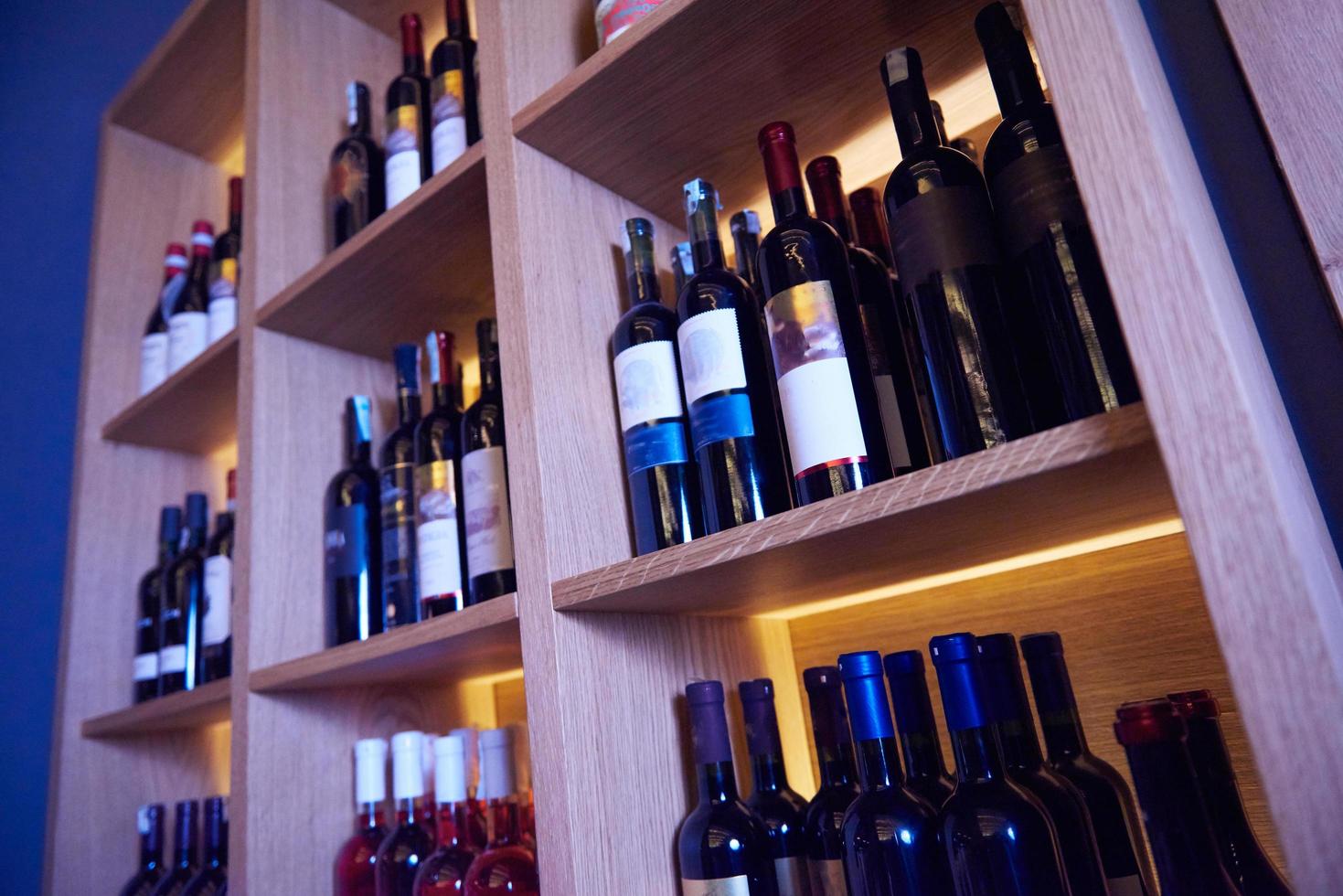 Wine bottles on a wooden shelf. photo