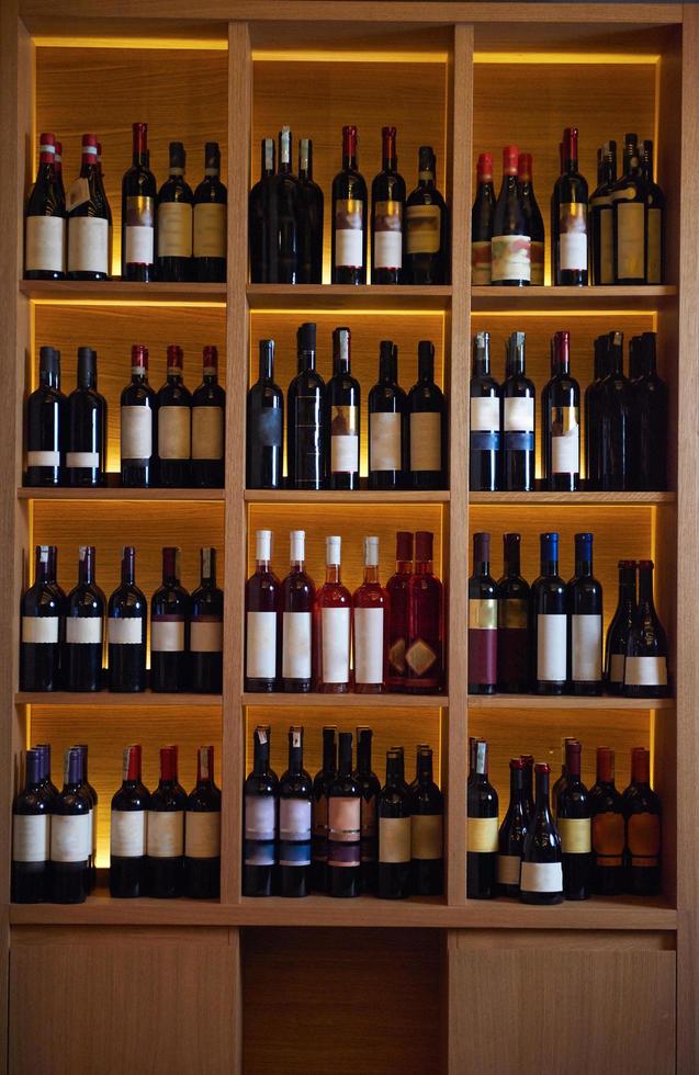 Wine bottles on a wooden shelf. photo