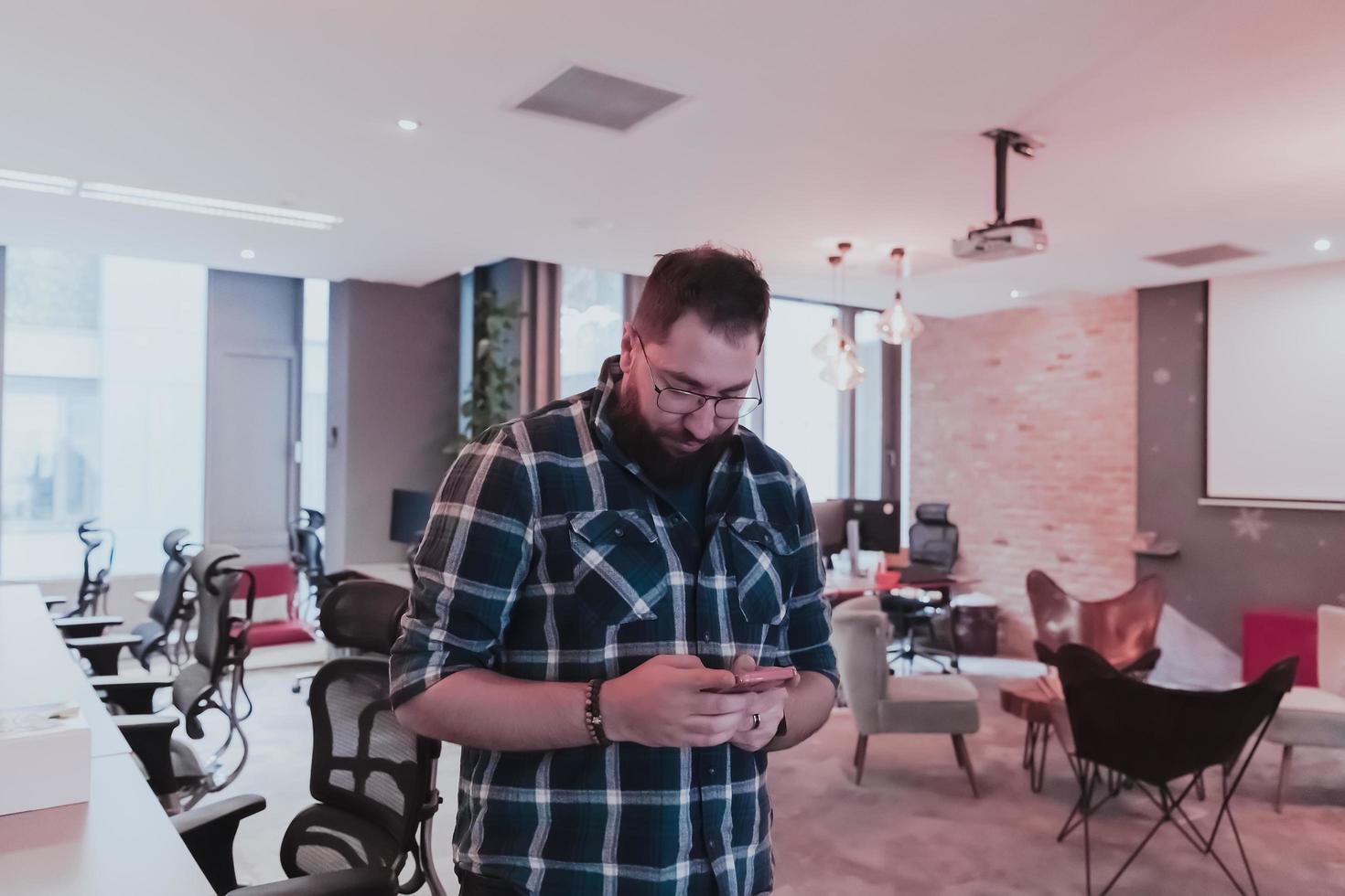 Office manager work in coworking space using smartphone analyzing online market trends, focused man worker reading financial news or browsing internet on phone. Technology concept photo