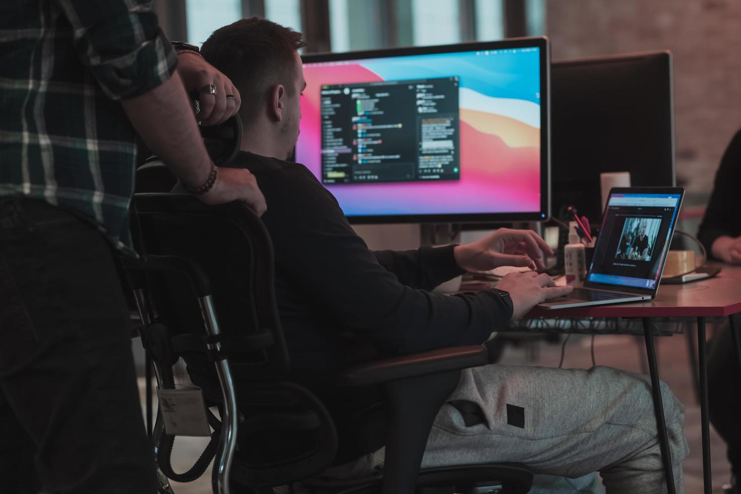 una foto de tres hombres mirando fijamente una computadora mientras están sentados en una oficina moderna. enfoque selectivo