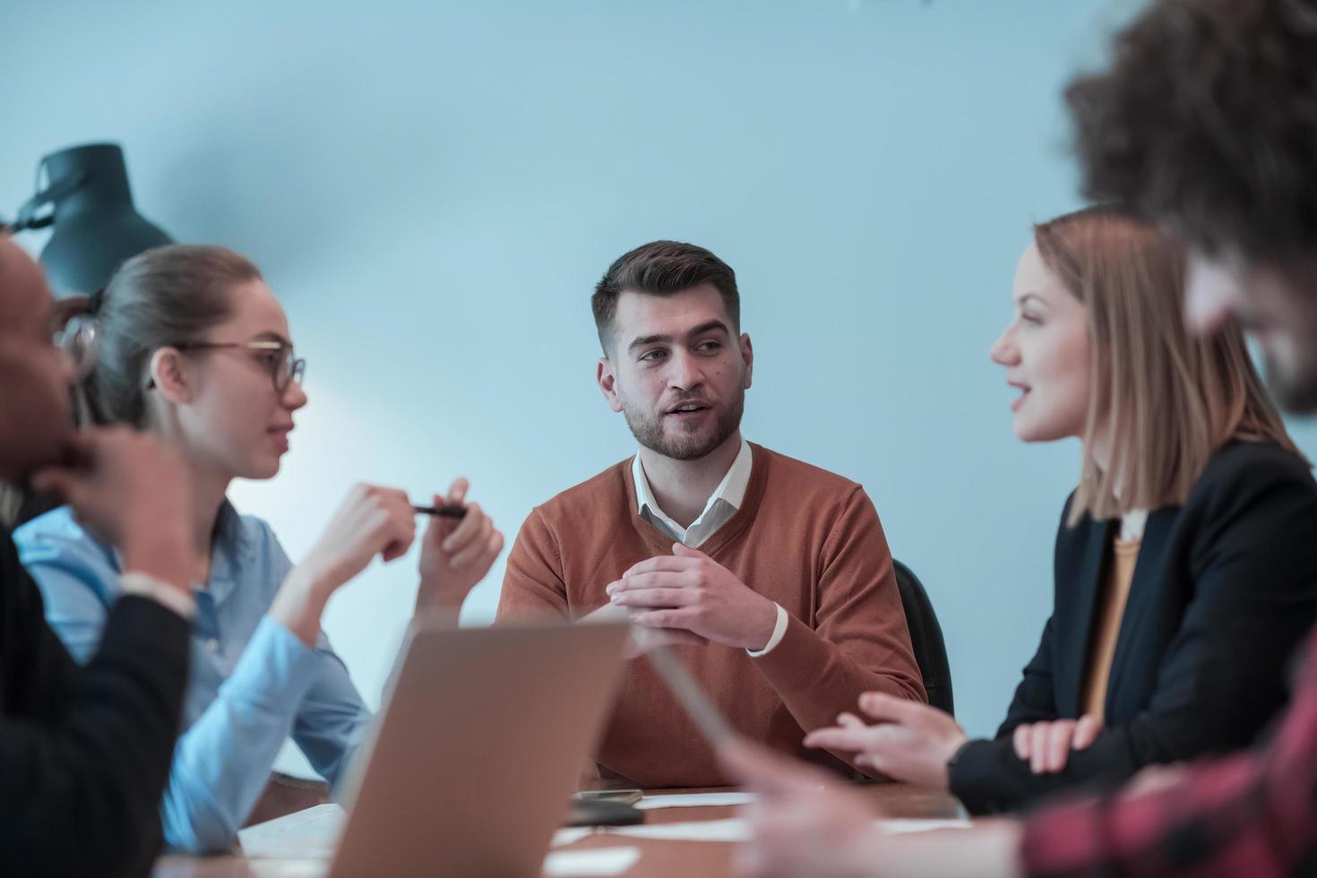 Successful team. Group of young multi-ethnic business people working and communicating together in creative office. Selective focus photo