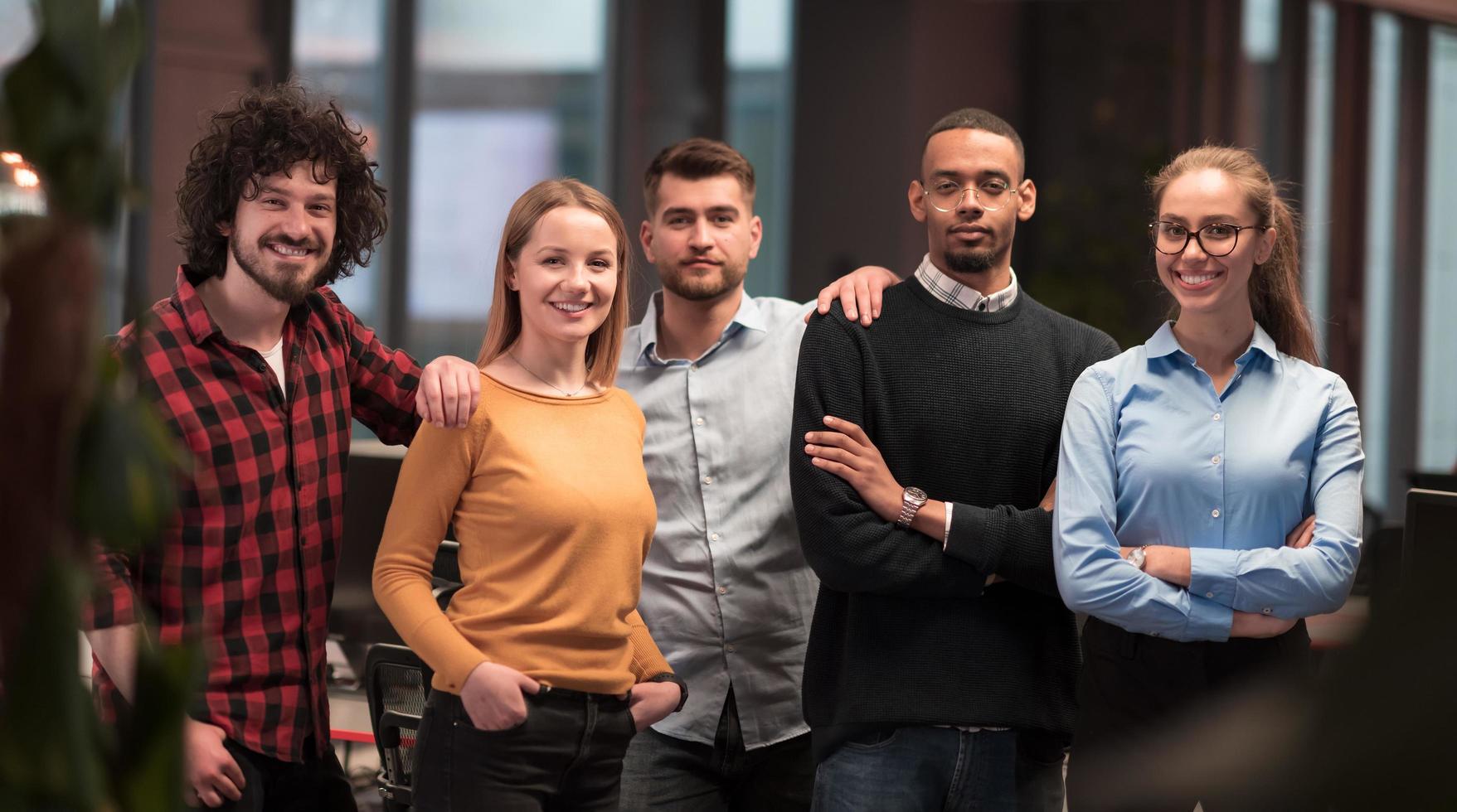 Portrait of successful creative business team looking at camera and smiling. Diverse business people standing together at startup. Selective focus photo