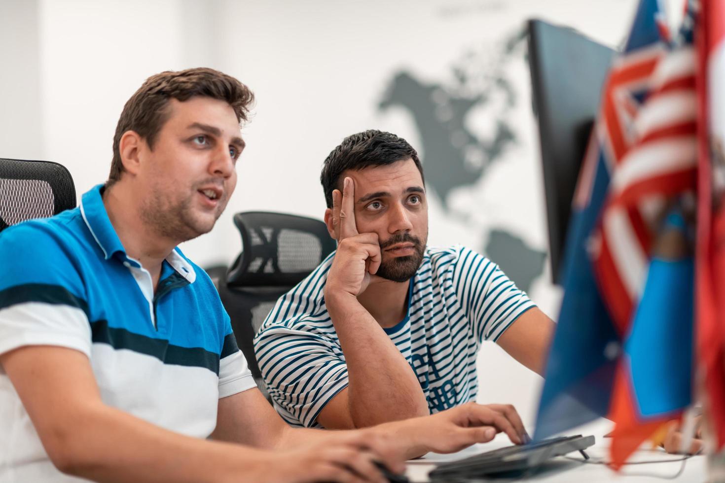 Group of Casual business man working on desktop computer in modern open plan startup office interior. Selective focus photo