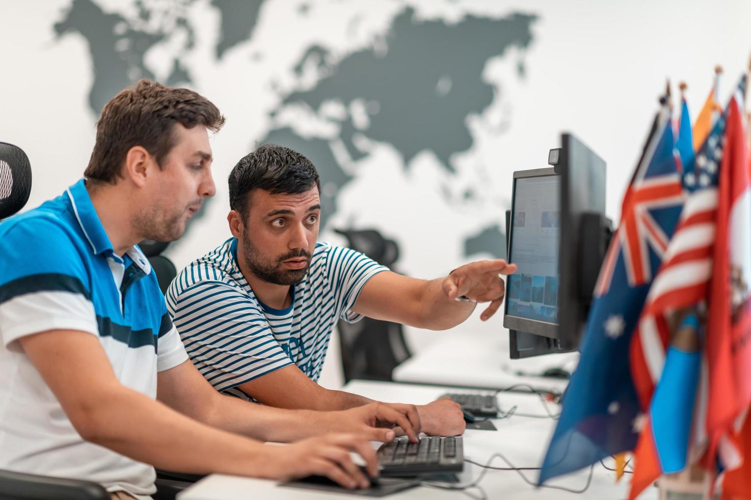 Group of Casual business man working on desktop computer in modern open plan startup office interior. Selective focus photo