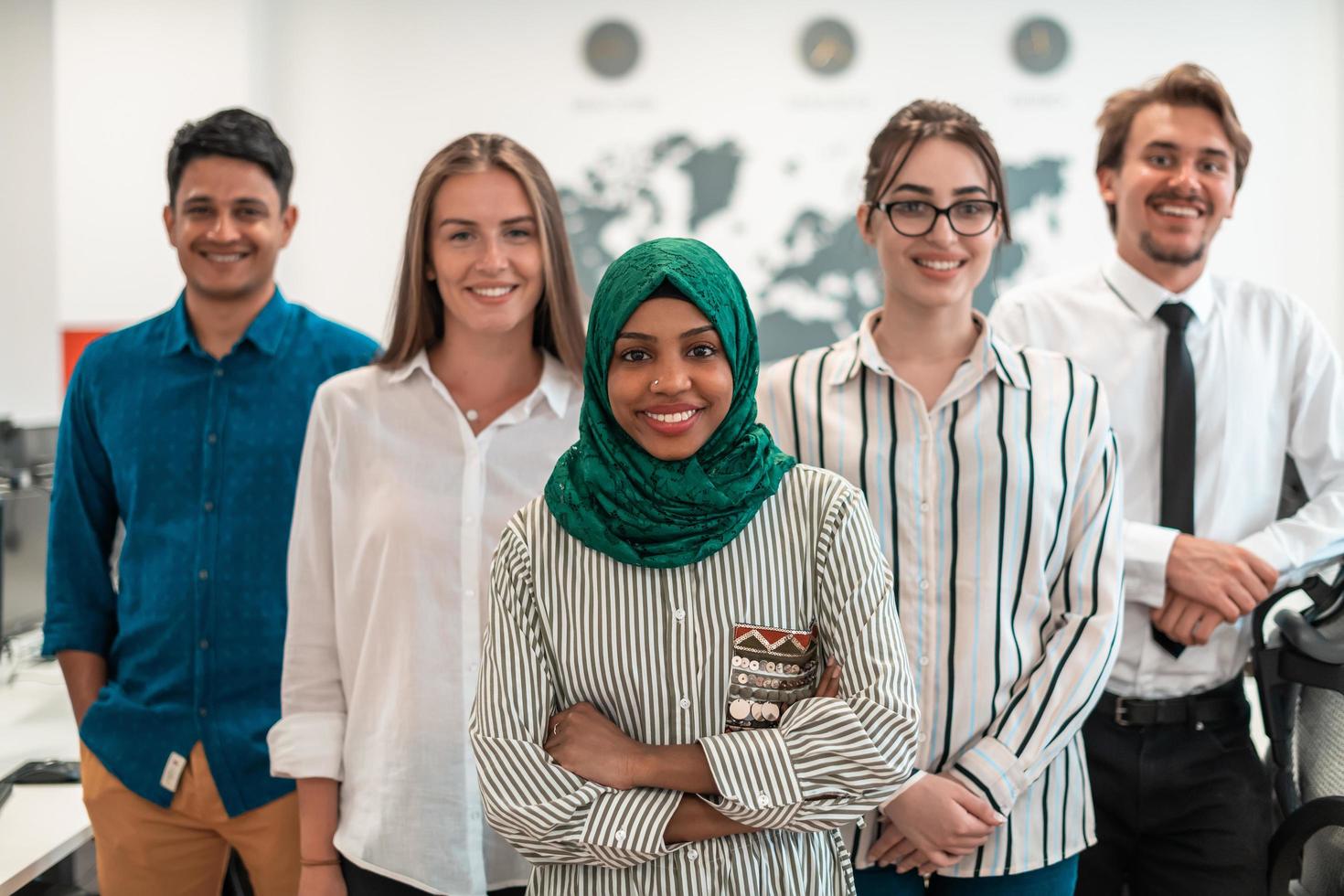 Portrait of young excited multiethnics business team of software developers standing and looking at camera at modern startup office photo