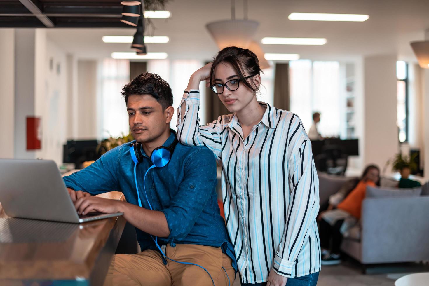 Multiethnic business people man with a female colleague working together on tablet and laptop computer in relaxation area of modern startup office photo