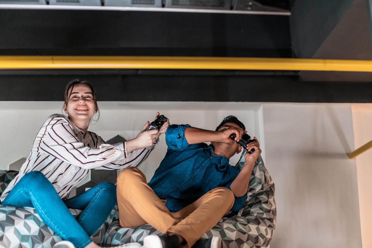 Work hard play hard. Workers Playing computer games man against woman during break in relaxation area at creative startup Office photo
