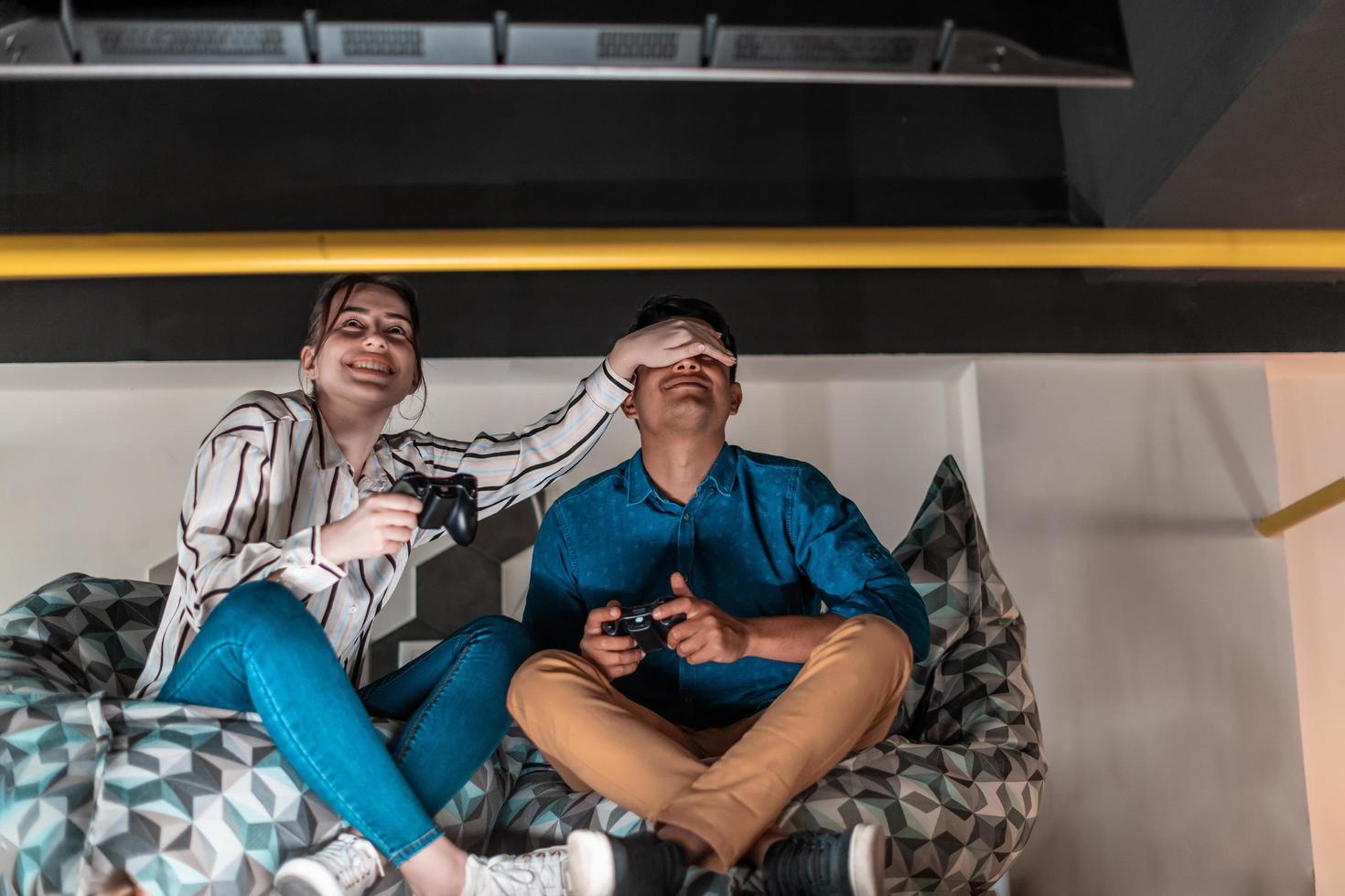Work hard play hard. Workers Playing computer games man against woman during break in relaxation area at creative startup Office photo