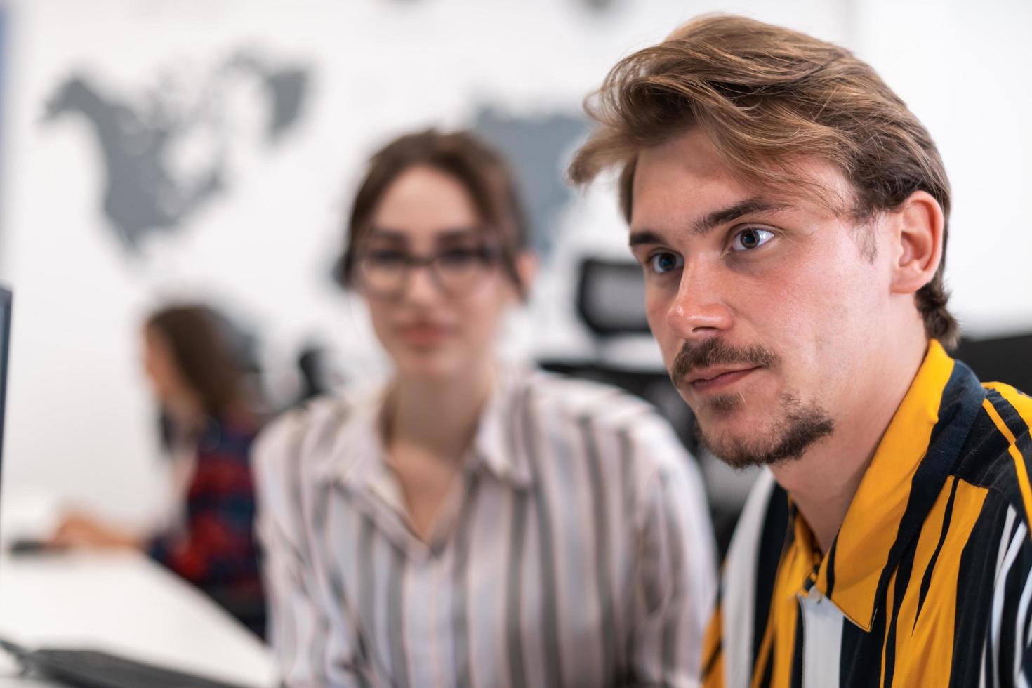Business couple working together on project using tablet and desktop computer at modern open plan startup office. Selective focus photo