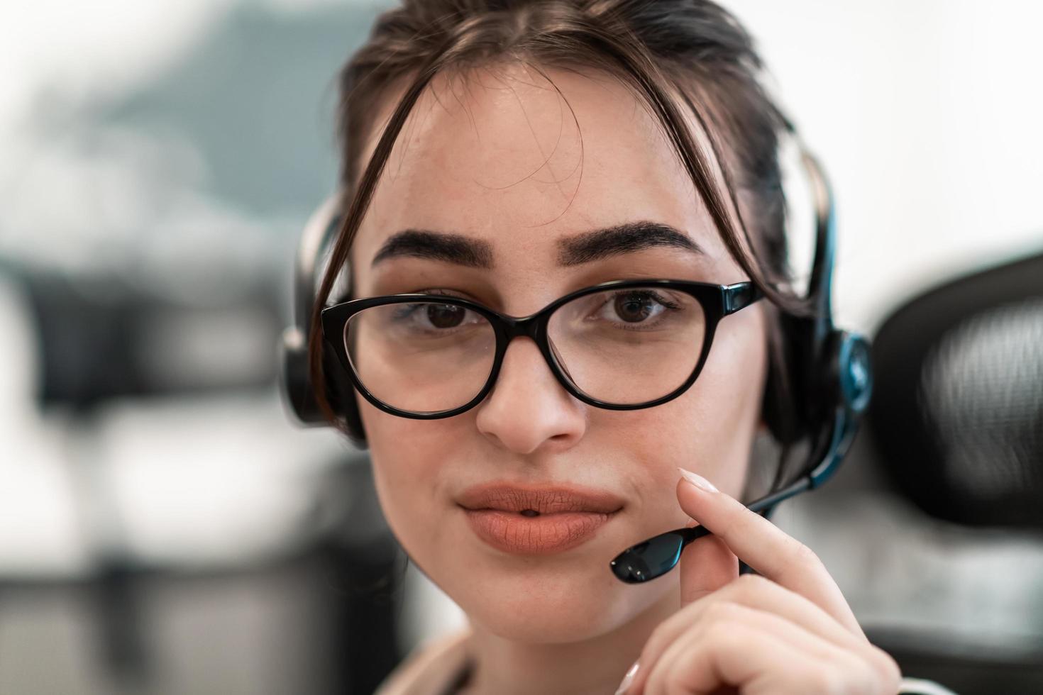 Business and technology concept - helpline female operator with headphones in call centre .Business woman with headsets working in a call center photo