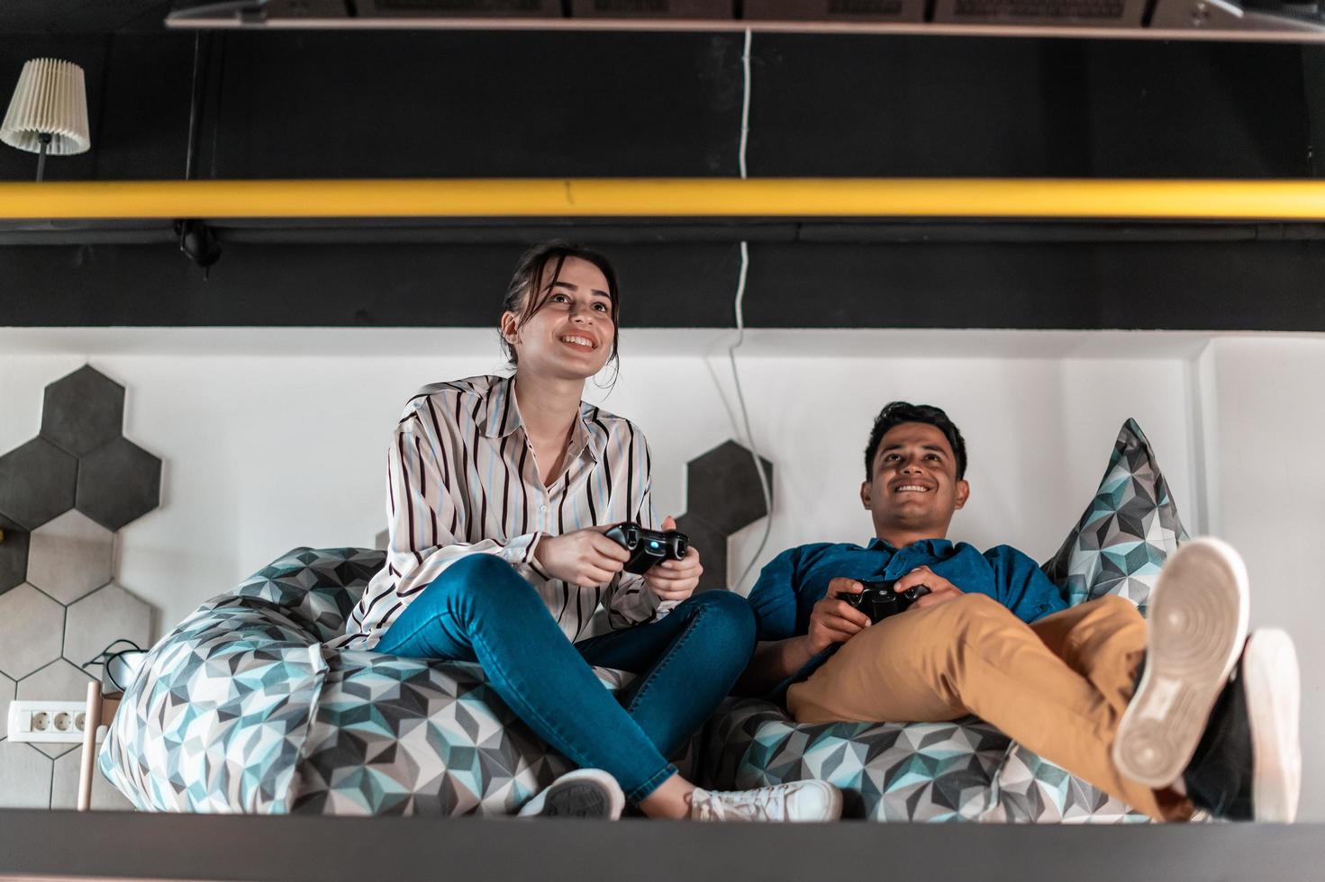 Work hard play hard. Workers Playing computer games man against woman during break in relaxation area at creative startup Office photo