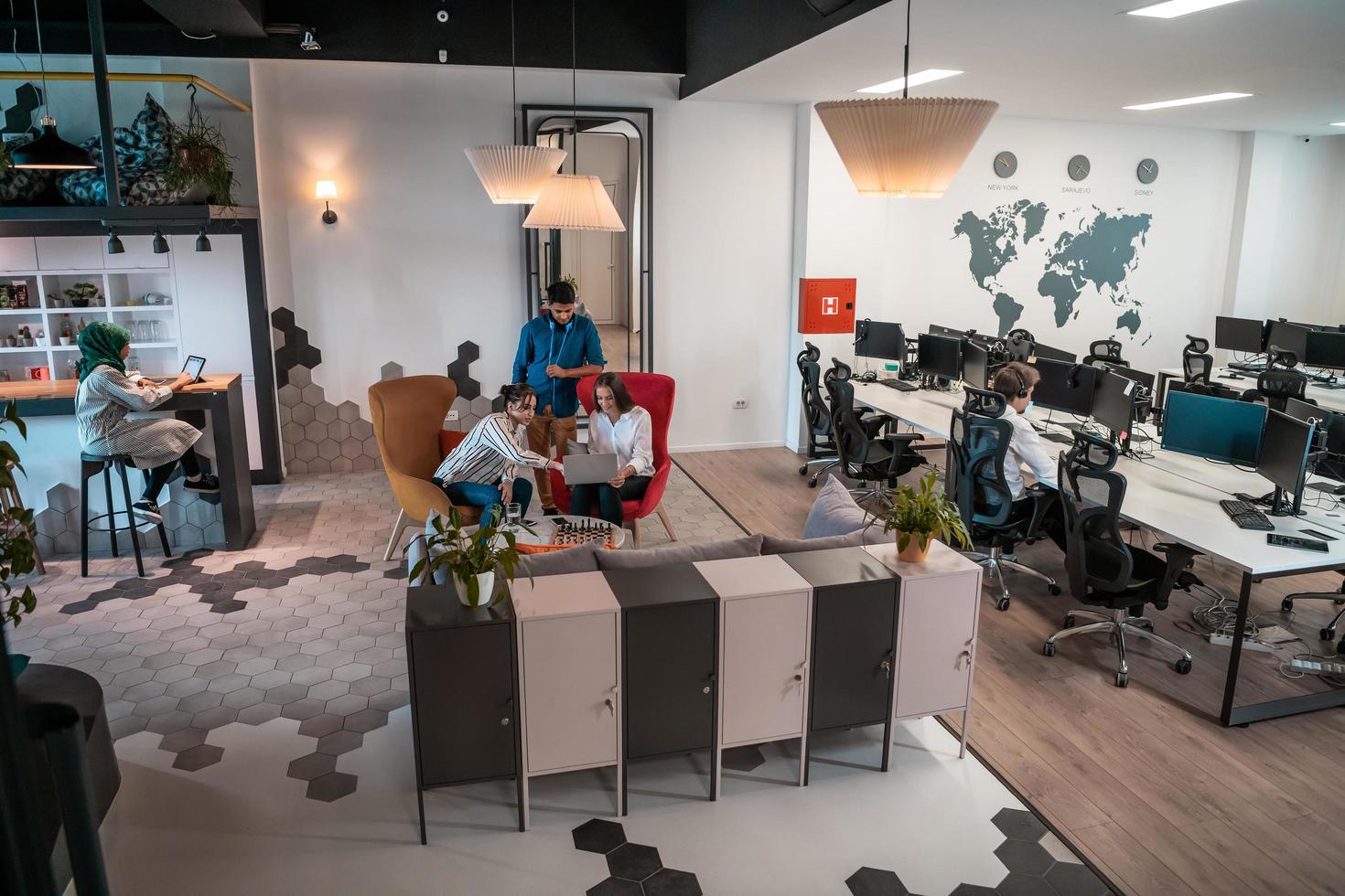 Group of casual multiethnic business people taking break from the work doing different things while enjoying free time in relaxation area at modern open plan startup office photo