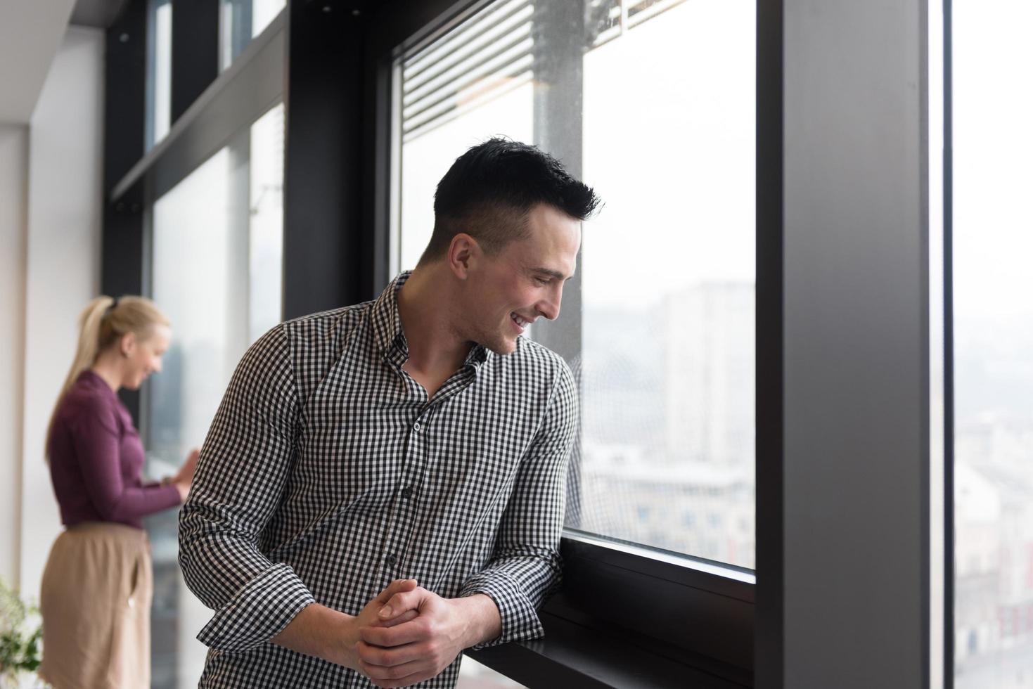 business man at office looking through window photo