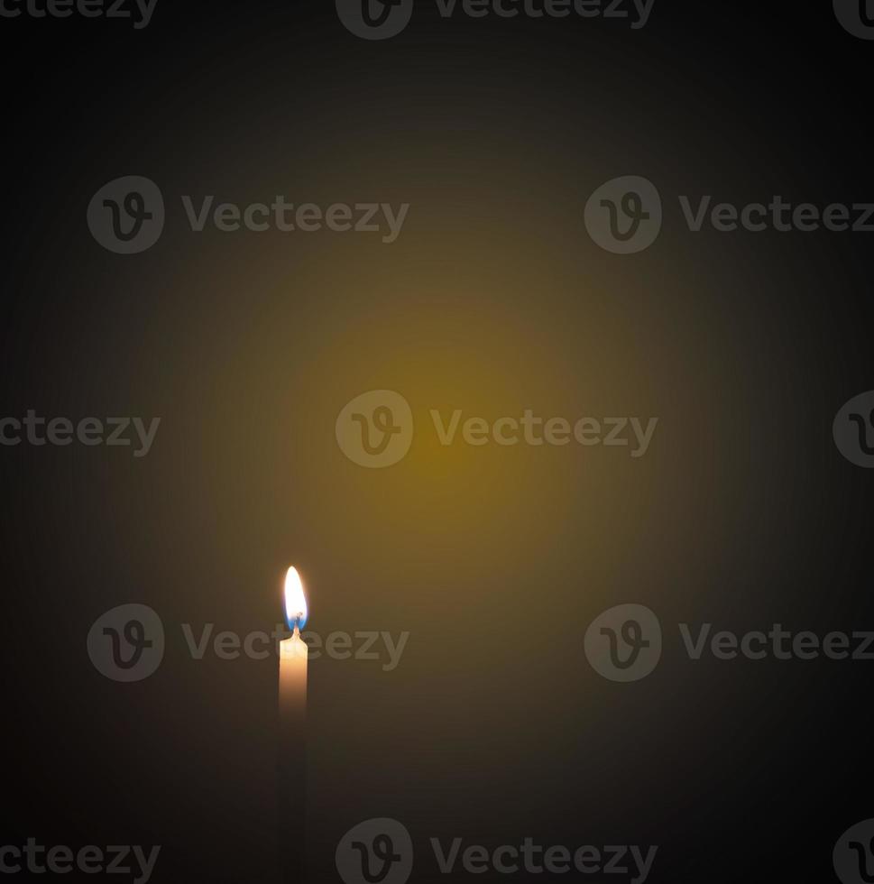 Candles were lit in the darkness to perform some rituals such as orange light. focus on the candle There is light on the background, there is orange on the black surface. photo