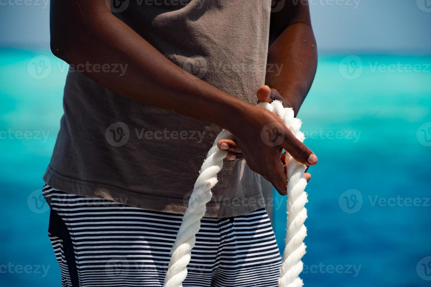 black hands holding white rope photo