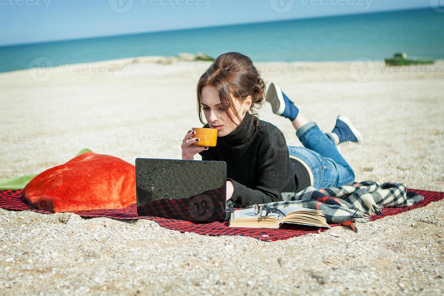 young woman enjoying her working on the beach photo
