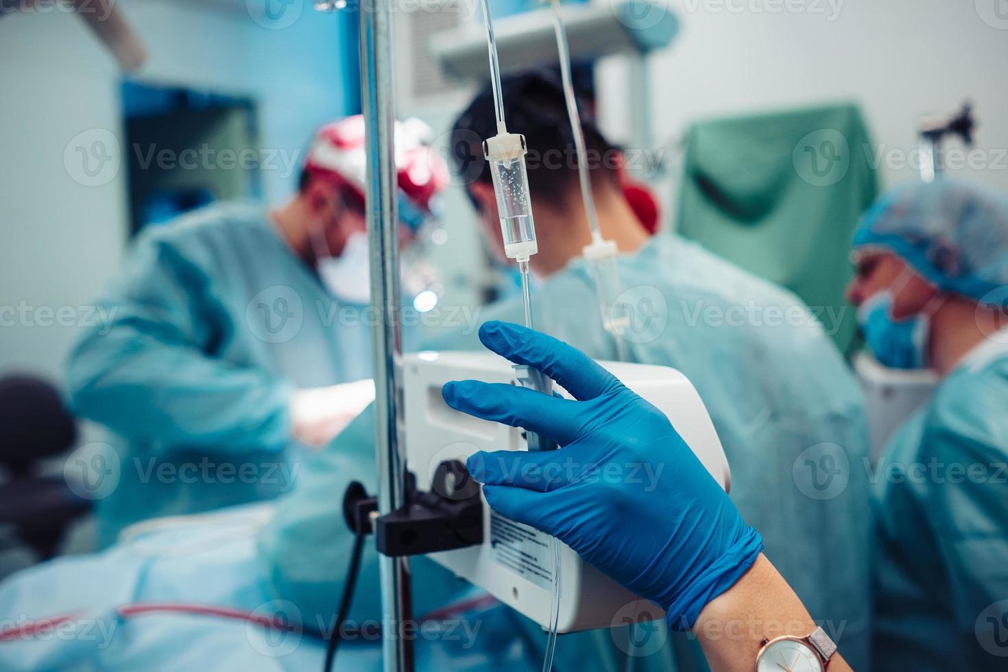 Nurse sets the patient's dropper on the background operation photo