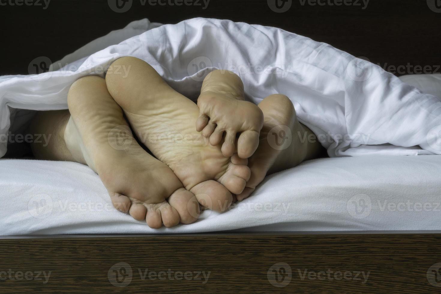 Man and woman legs under duvet photo
