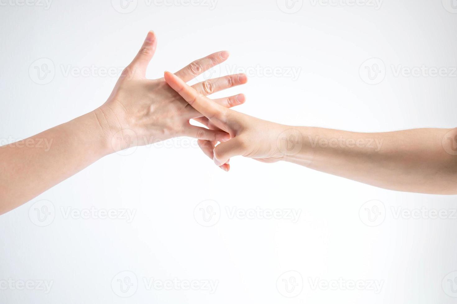 Hands of two people playing rock paper scissors, hands showing shape of scissors symbol and paper symbol, concept of business competition. photo