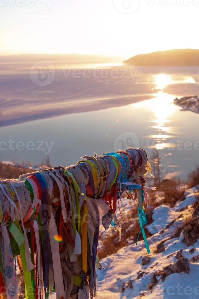 Beautiful scene of Lake Baikal in winter in evening that sunset light reflected in water and some area become ice. photo